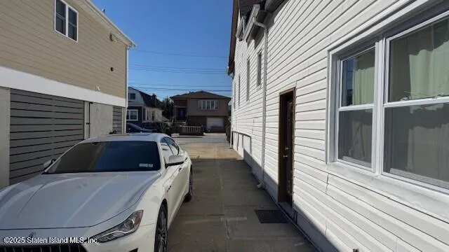 a view of a house with a barbeque and wooden stairs