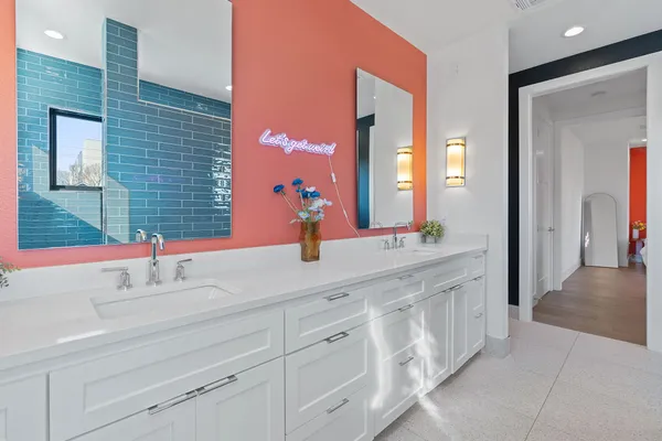 a bathroom with a double vanity sink a toilet and a mirror