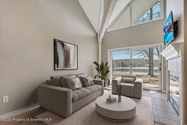 a view of kitchen and empty room with wooden floor