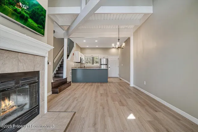 a kitchen with granite countertop a refrigerator a sink a stove top oven and white cabinets