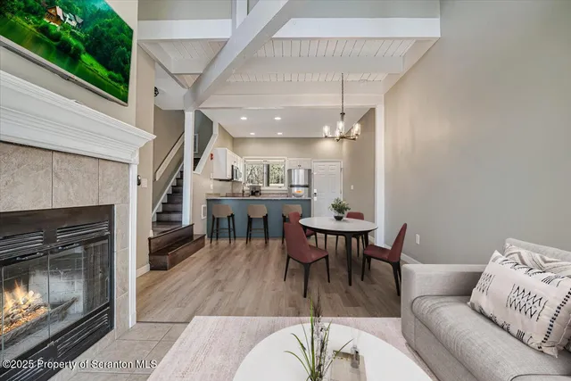 a open kitchen with granite countertop a stove top oven a sink dishwasher and a fireplace with wooden floor