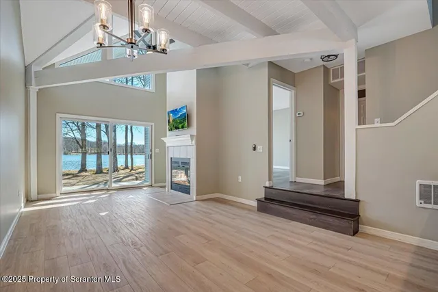 a view of a livingroom with wooden floor and a fireplace