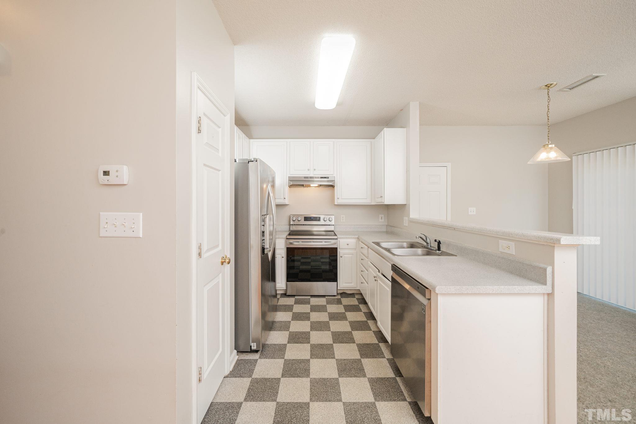 114 Calebra Way Cary, NC 27519 - Photo 18 of 50 a kitchen with a stove a sink and a refrigerator