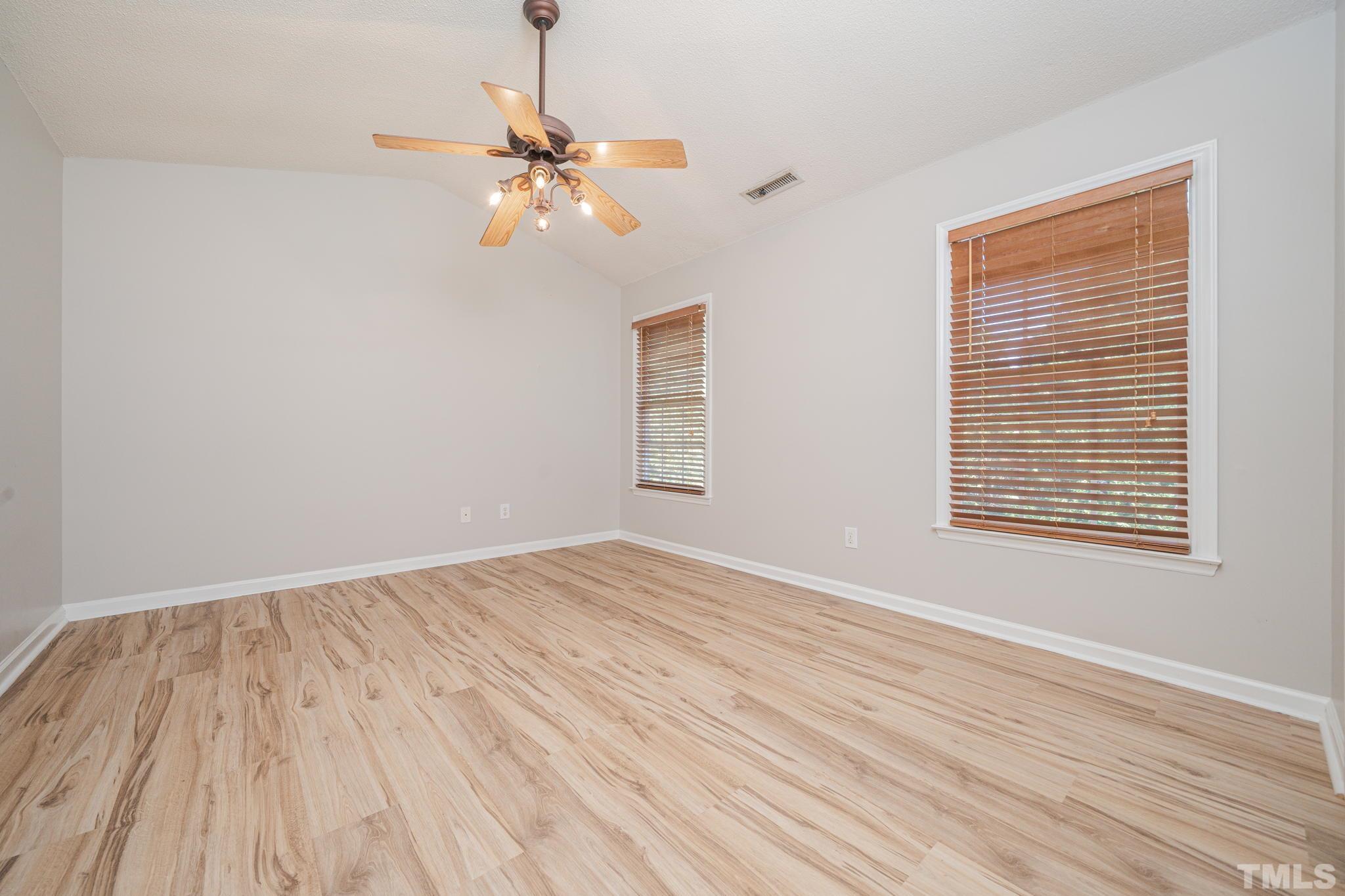 114 Calebra Way Cary, NC 27519 - Photo 22 of 50 a view of an empty room with wooden floor and a window