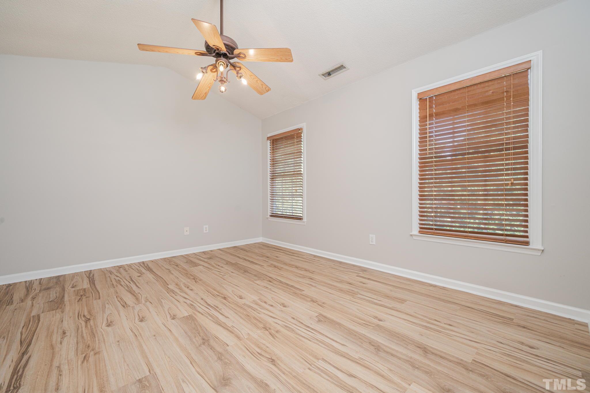 114 Calebra Way Cary, NC 27519 - Photo 23 of 50 a view of an empty room with wooden floor and a window