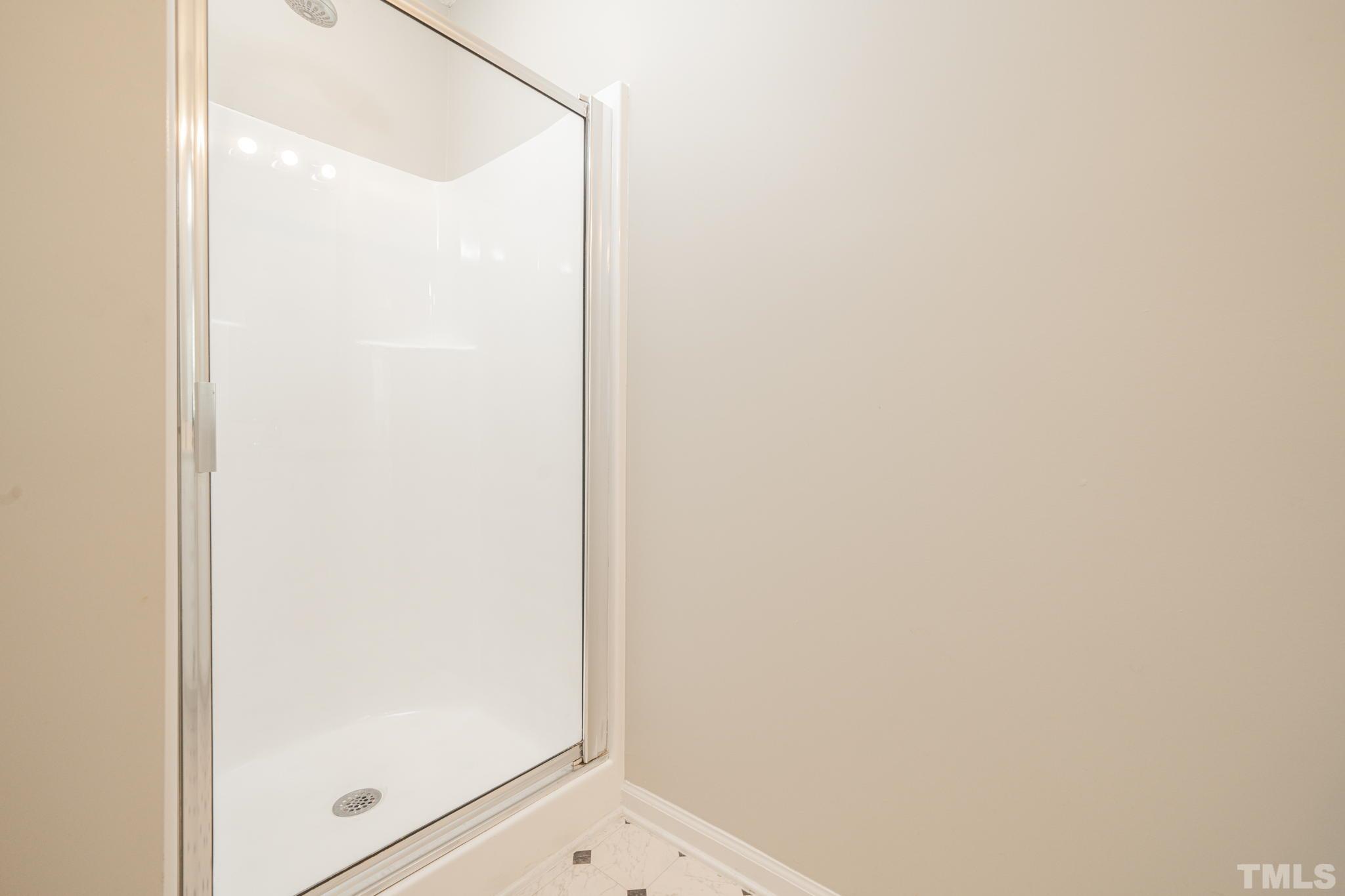 114 Calebra Way Cary, NC 27519 - Photo 27 of 50 a bathroom with a glass shower door