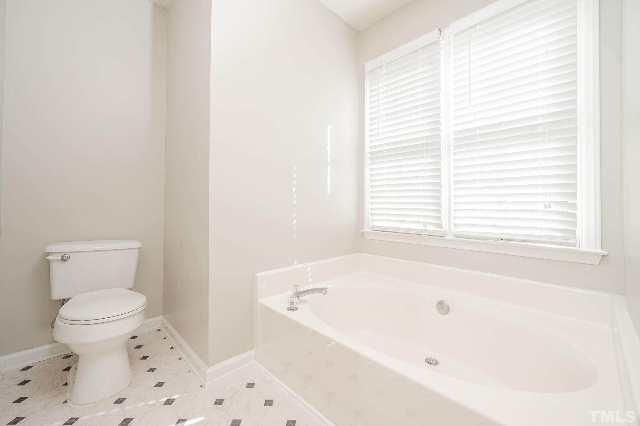 114 Calebra Way Cary, NC 27519 - Photo 28 of 50 a white bath tub sitting next to a toilet