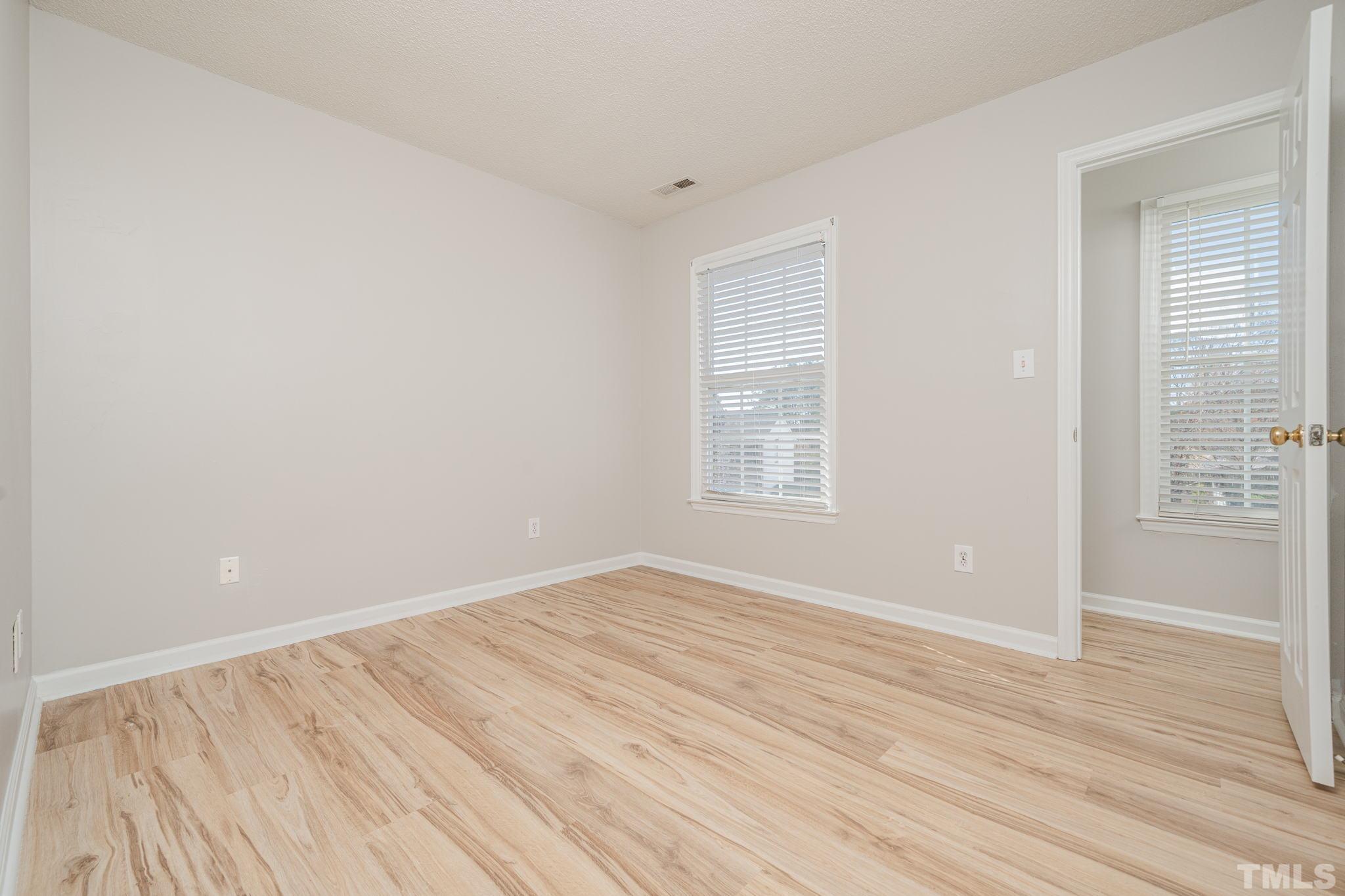 114 Calebra Way Cary, NC 27519 - Photo 32 of 50 an empty room with wooden floor and windows
