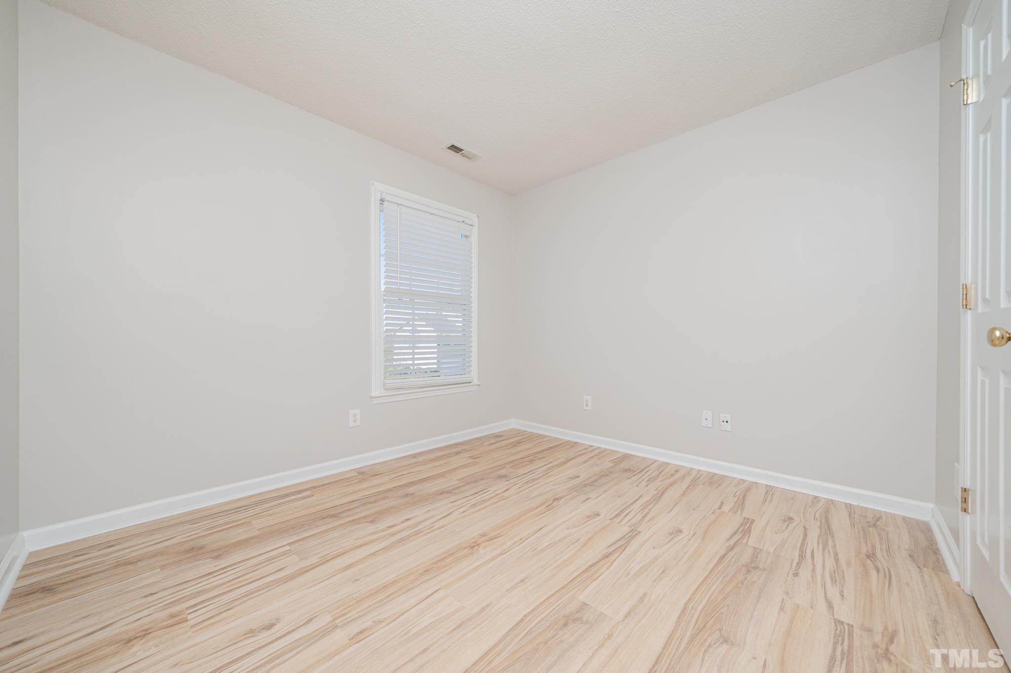 114 Calebra Way Cary, NC 27519 - Photo 33 of 50 an empty room with wooden floor and windows