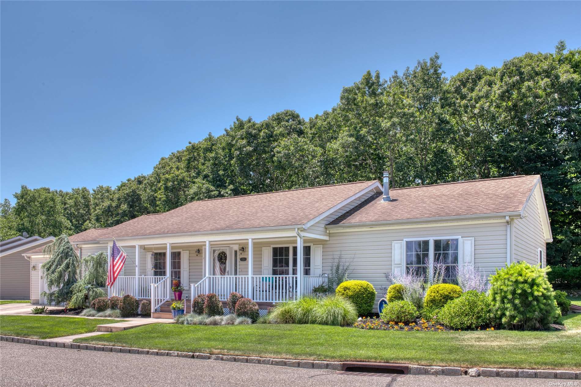 a view of a house with a big yard plants and large trees