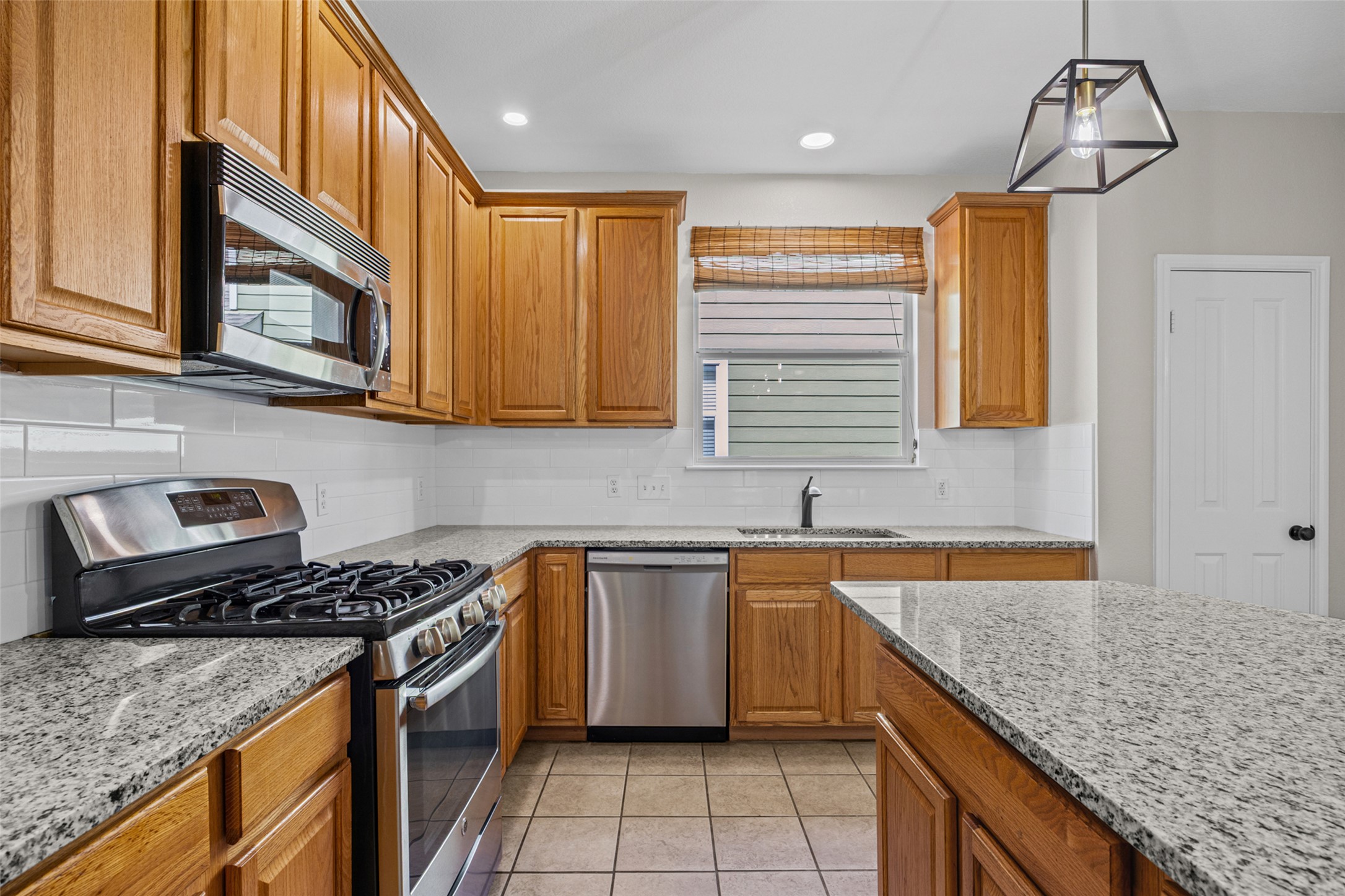 5881 Fergus Kyle, TX 78640 - Photo 7 of 40 Gleaming new granite countertops pair beautifully with warm wood cabinetry and durable tile flooring.