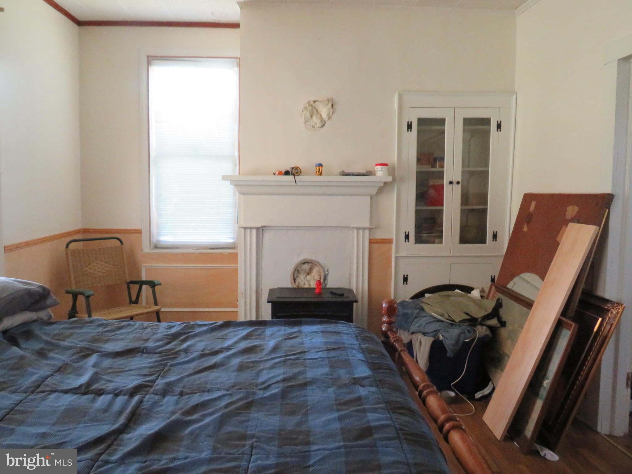 26955 Johnson Creek Road Crisfield, MD 21817 - Photo 21 of 35 a bedroom with furniture and a fireplace