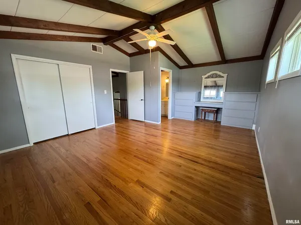 a view of empty room with wooden floor