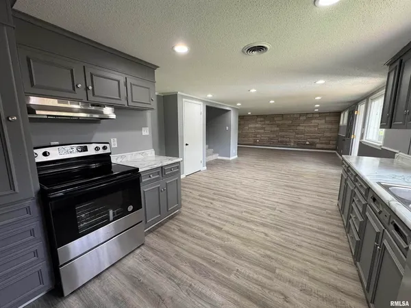 a large kitchen with stainless steel appliances granite countertop a stove and a sink