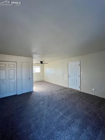 a view of an empty room with a kitchen