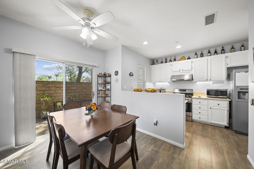 1838 Amberleaf Lane Simi Valley, CA 93065 - Photo 12 of 39 a kitchen with stainless steel appliances granite countertop a stove a refrigerator a sink dishwasher a dining table and chairs with wooden floor