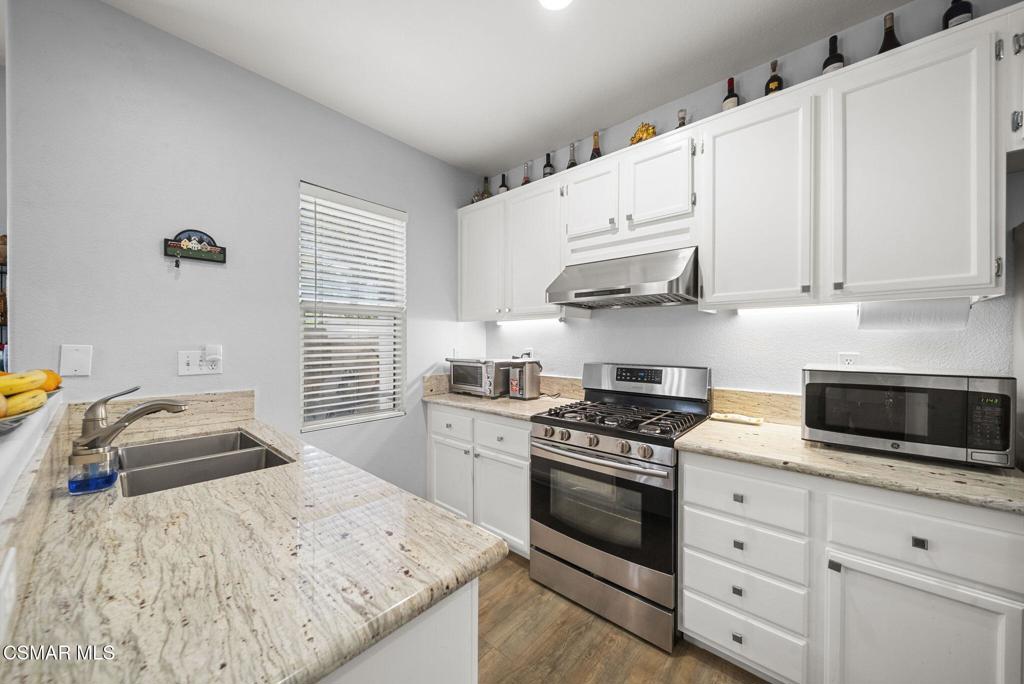 1838 Amberleaf Lane Simi Valley, CA 93065 - Photo 14 of 39 a kitchen with granite countertop a sink a stove and cabinets