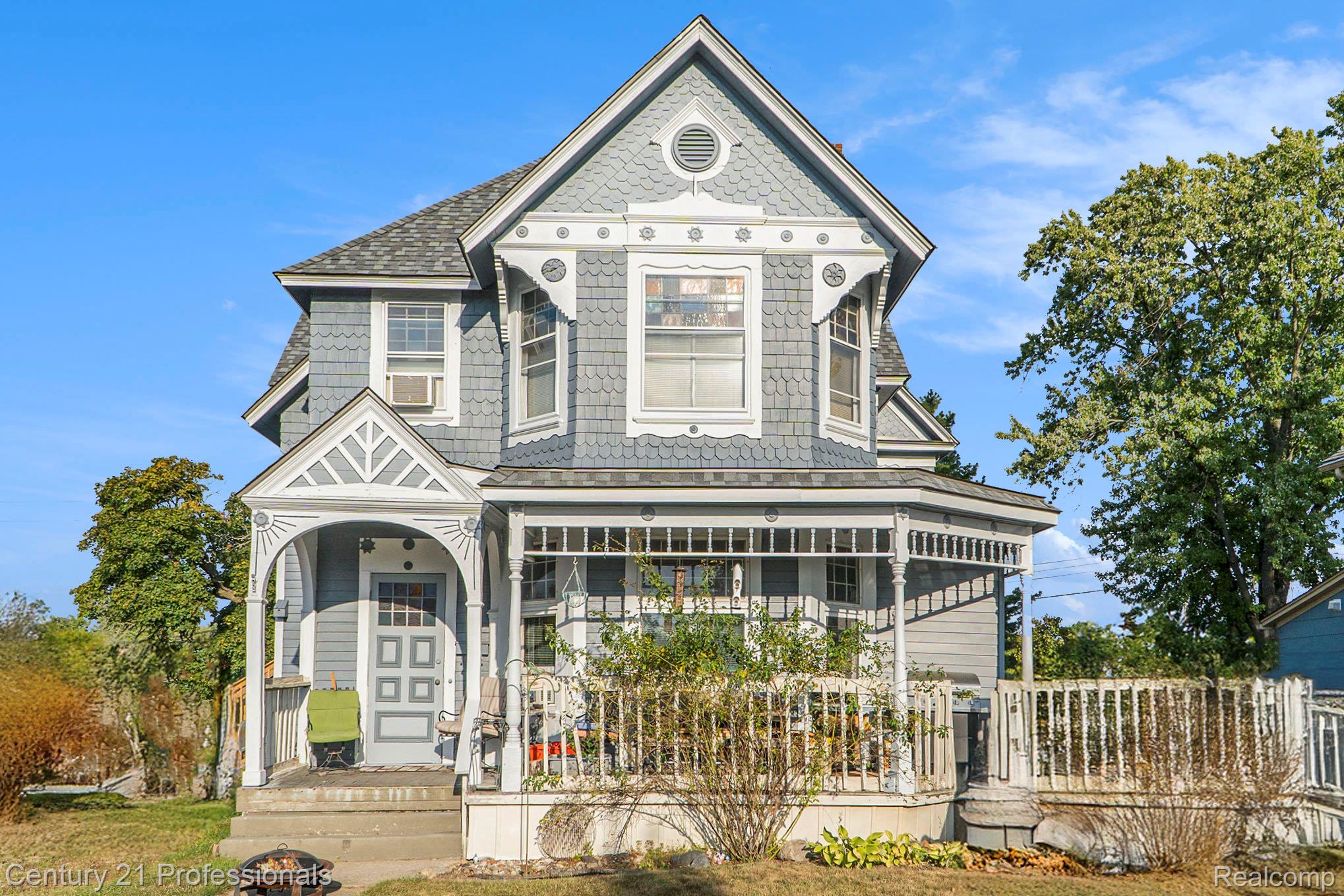 Victorian house featuring a porch and a shingled roof