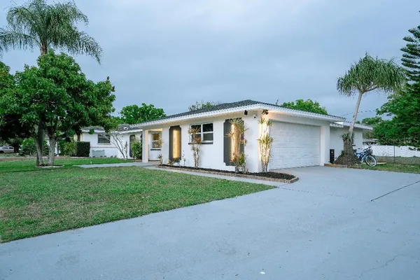 front view of a house and a yard and trees