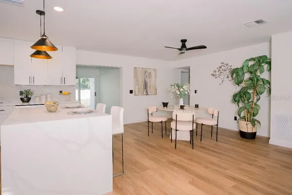 a living room with furniture dining table and wooden floor