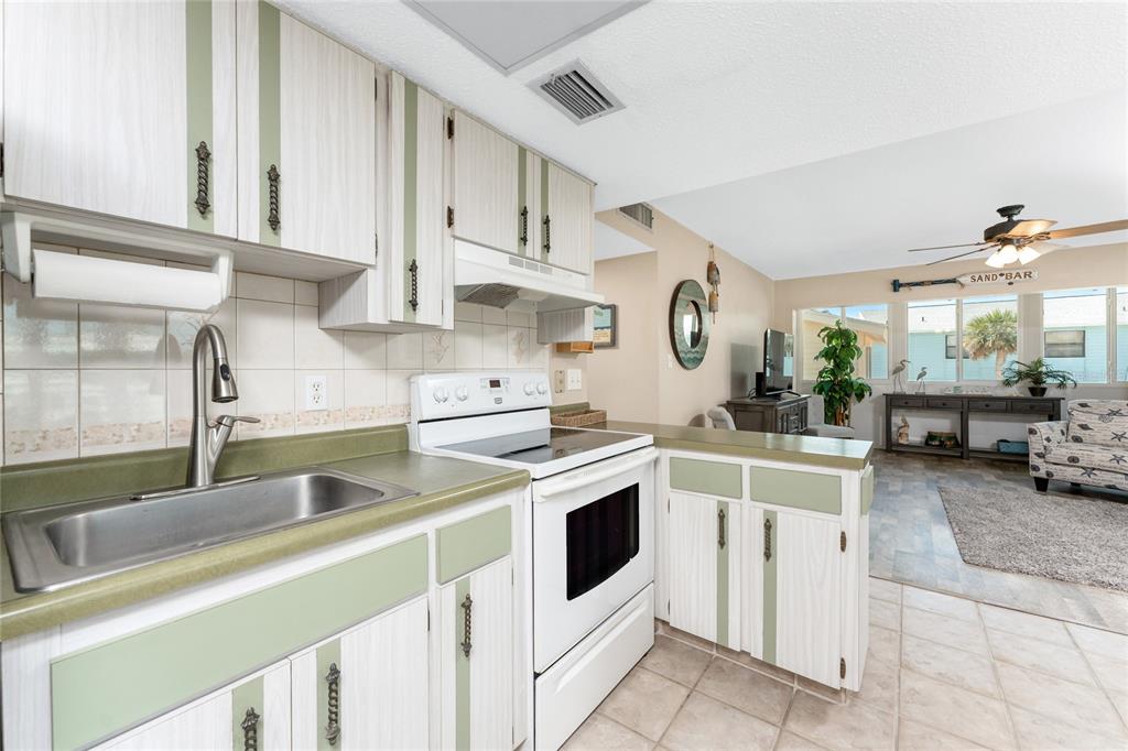 5055 North Beach Road, Unit 208 Englewood, FL 34223 - Photo 16 of 43 a kitchen with cabinets and white appliances