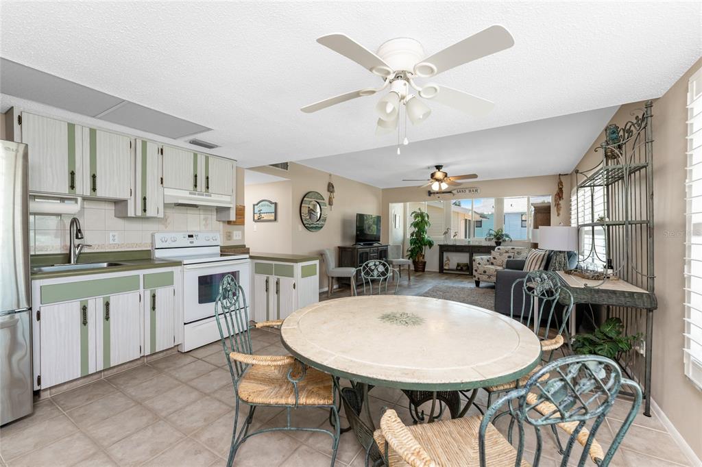 5055 North Beach Road, Unit 208 Englewood, FL 34223 - Photo 17 of 43 a very nice looking dining room with kitchen island a stove a table and chairs