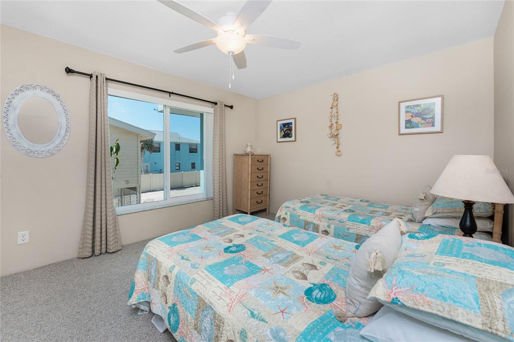 5055 North Beach Road, Unit 208 Englewood, FL 34223 - Photo 24 of 43 a bedroom with a bed and a chandelier