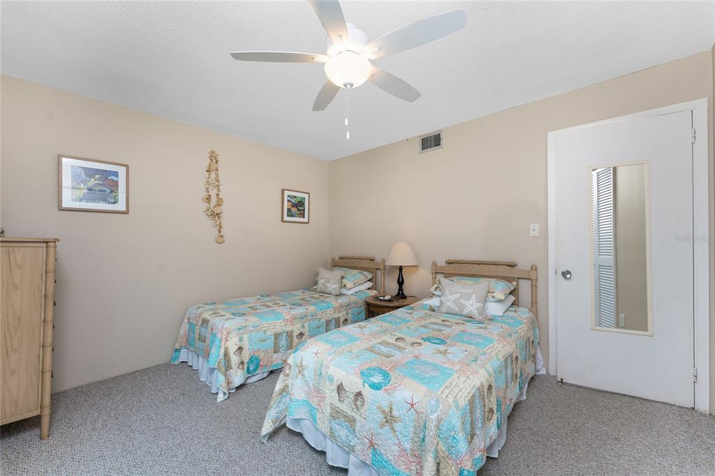 5055 North Beach Road, Unit 208 Englewood, FL 34223 - Photo 25 of 43 a bedroom with two beds and a chandelier