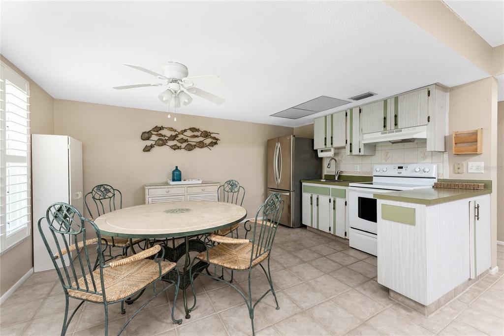 5055 North Beach Road, Unit 208 Englewood, FL 34223 - Photo 5 of 43 a kitchen with white cabinets stainless steel appliances and dining table