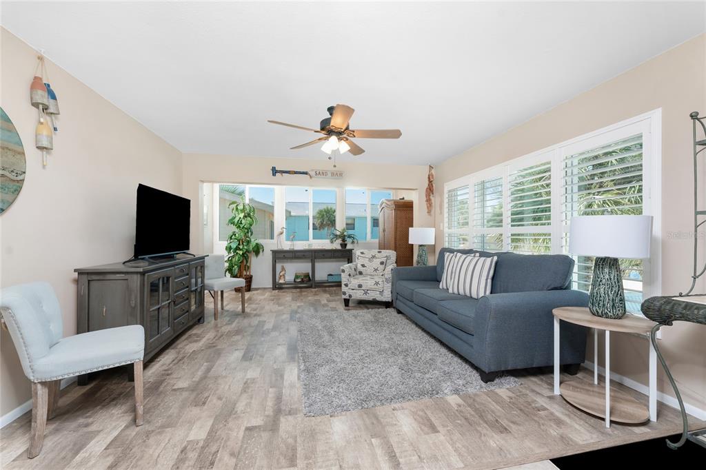 5055 North Beach Road, Unit 208 Englewood, FL 34223 - Photo 10 of 43 a living room with furniture a flat screen tv and a large window