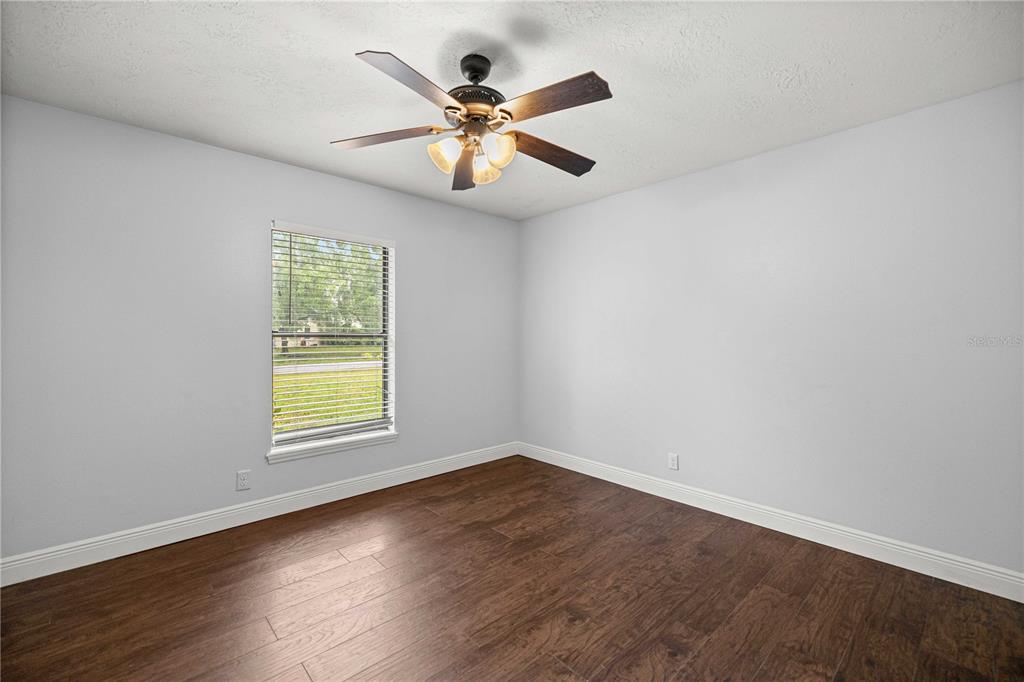 10500 Southwest 74th Court Ocala, FL 34476 - Photo 22 of 28 an empty room with a window and wooden floor