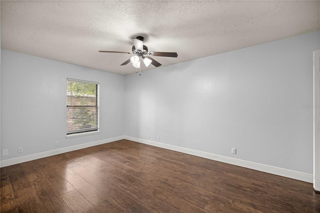 10500 Southwest 74th Court Ocala, FL 34476 - Photo 23 of 28 a view of a big room with wooden floor a chandelier fan and windows