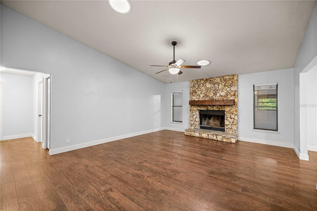 10500 Southwest 74th Court Ocala, FL 34476 - Photo 5 of 28 a view of an empty room with wooden floor fireplace and a window