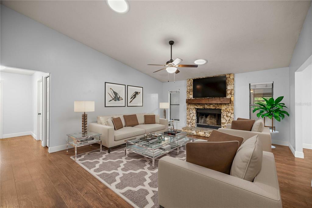 10500 Southwest 74th Court Ocala, FL 34476 - Photo 6 of 28 a living room with furniture a fireplace and a flat screen tv