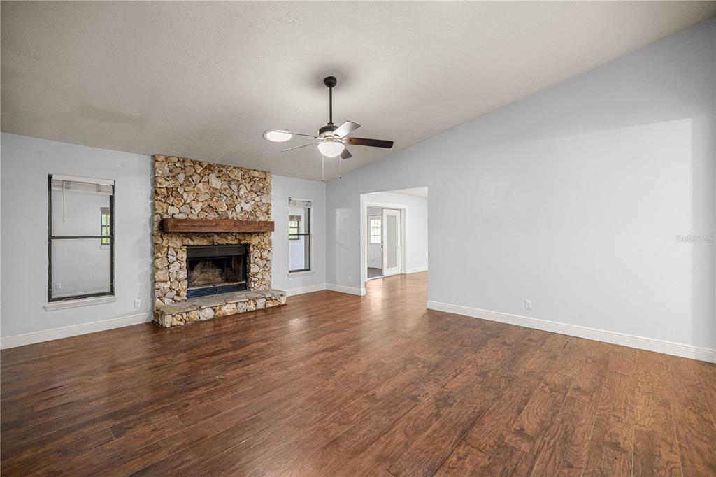 10500 Southwest 74th Court Ocala, FL 34476 - Photo 7 of 28 a view of an empty room with wooden floor fireplace and a window