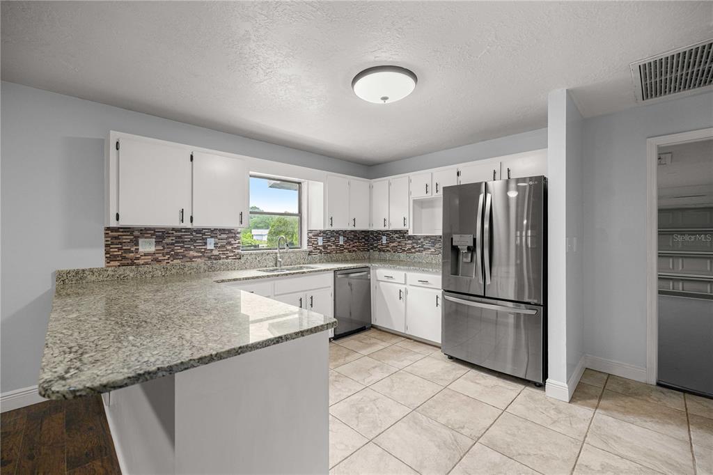10500 Southwest 74th Court Ocala, FL 34476 - Photo 9 of 28 a kitchen with granite countertop a refrigerator sink and cabinets