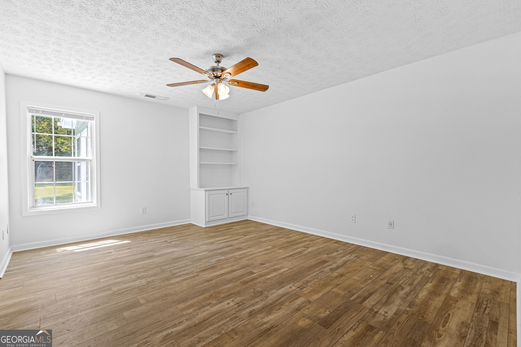 484 Creek Crossing Court Grayson, GA 30017 - Photo 11 of 17 a view of an empty room with window and wooden floor