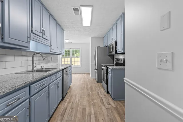 a kitchen with refrigerator cabinets and wooden floor