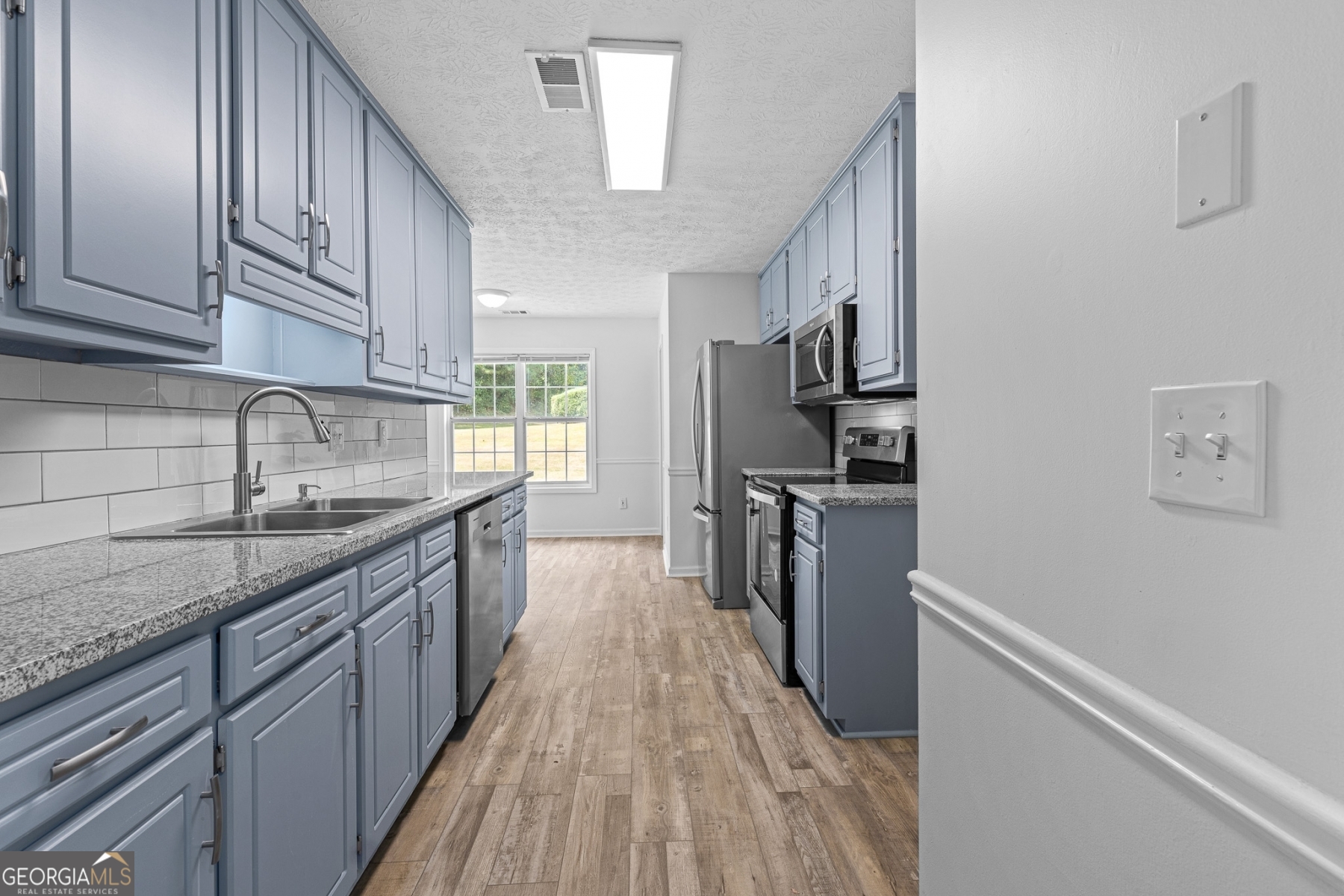 484 Creek Crossing Court Grayson, GA 30017 - Photo 2 of 17 a kitchen with refrigerator cabinets and wooden floor