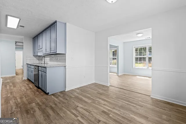 a view of kitchen with granite countertop cabinets and wooden floor