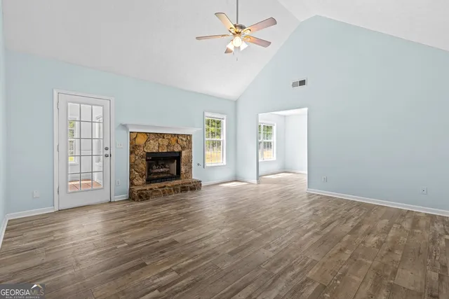 an empty room with windows and fireplace