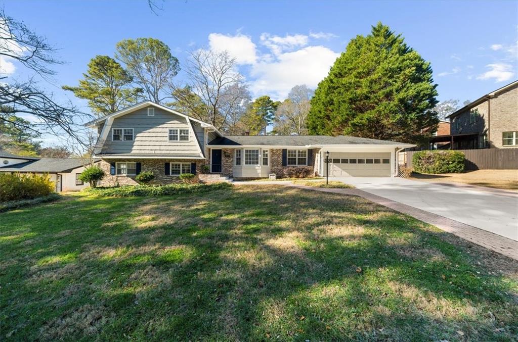 a front view of a house with a garden and trees