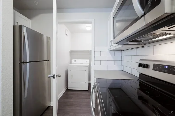 a kitchen with a refrigerator and white cabinets