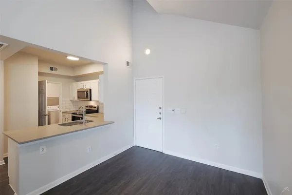 a kitchen with granite countertop a refrigerator and a stove top oven