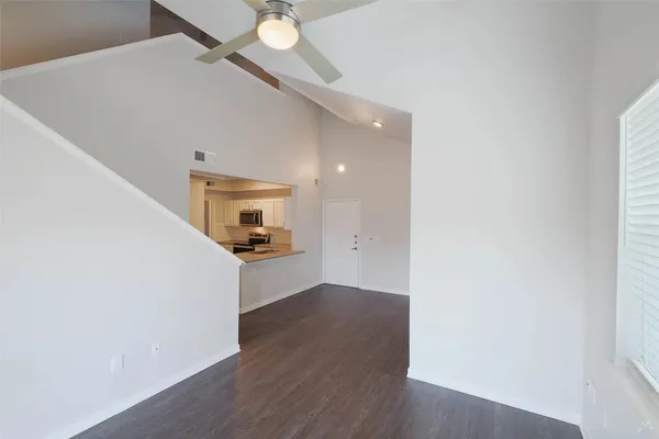a view of a hallway with wooden floor and staircase