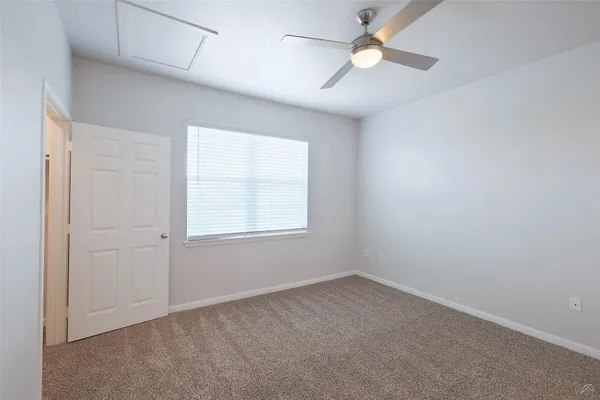 an empty room with a window and a fan