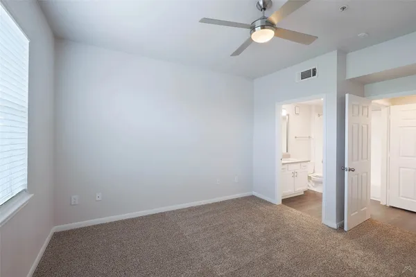 an empty room with closet and a chandelier fan