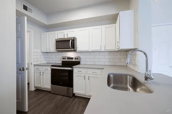a kitchen with a sink stove and microwave