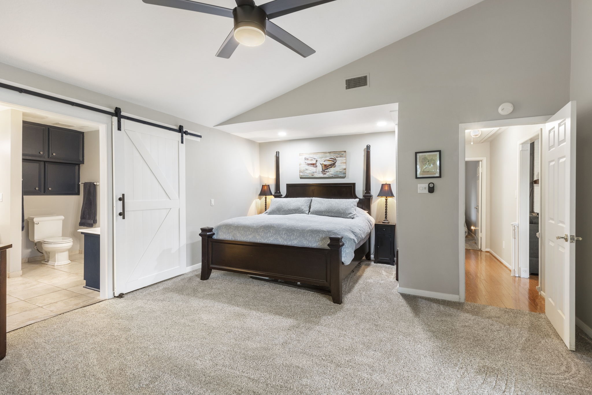 245 Lakeland Road Huntsville, TX 77320 - Photo 19 of 49 The large primary bedroom offers ample space for relaxation, and stylish barn doors leading to the primary bathroom