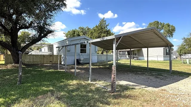 a backyard of a house with table and chairs